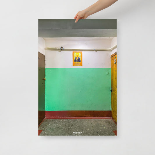 Hand holding large 91x61cm print depicting a typical Russian apartment stairwell featuring an icon of Holy Blessed Matrona of Moscow on the wall. From arthodox.com