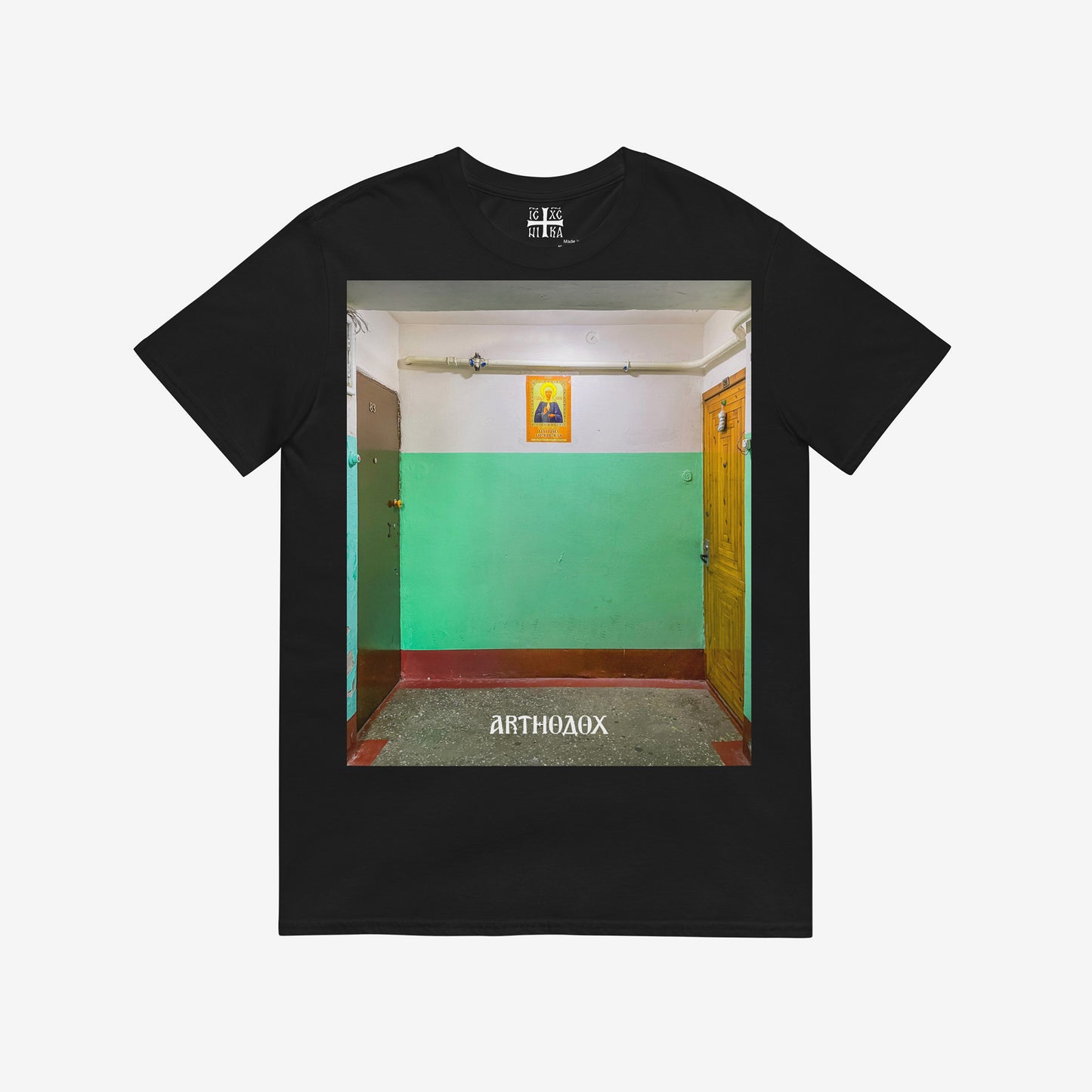 Black unisex T-shirt with a large print depicting a typical Russian apartment stairwell featuring an icon of Holy Blessed Matrona of Moscow on the wall. From arthodox.com