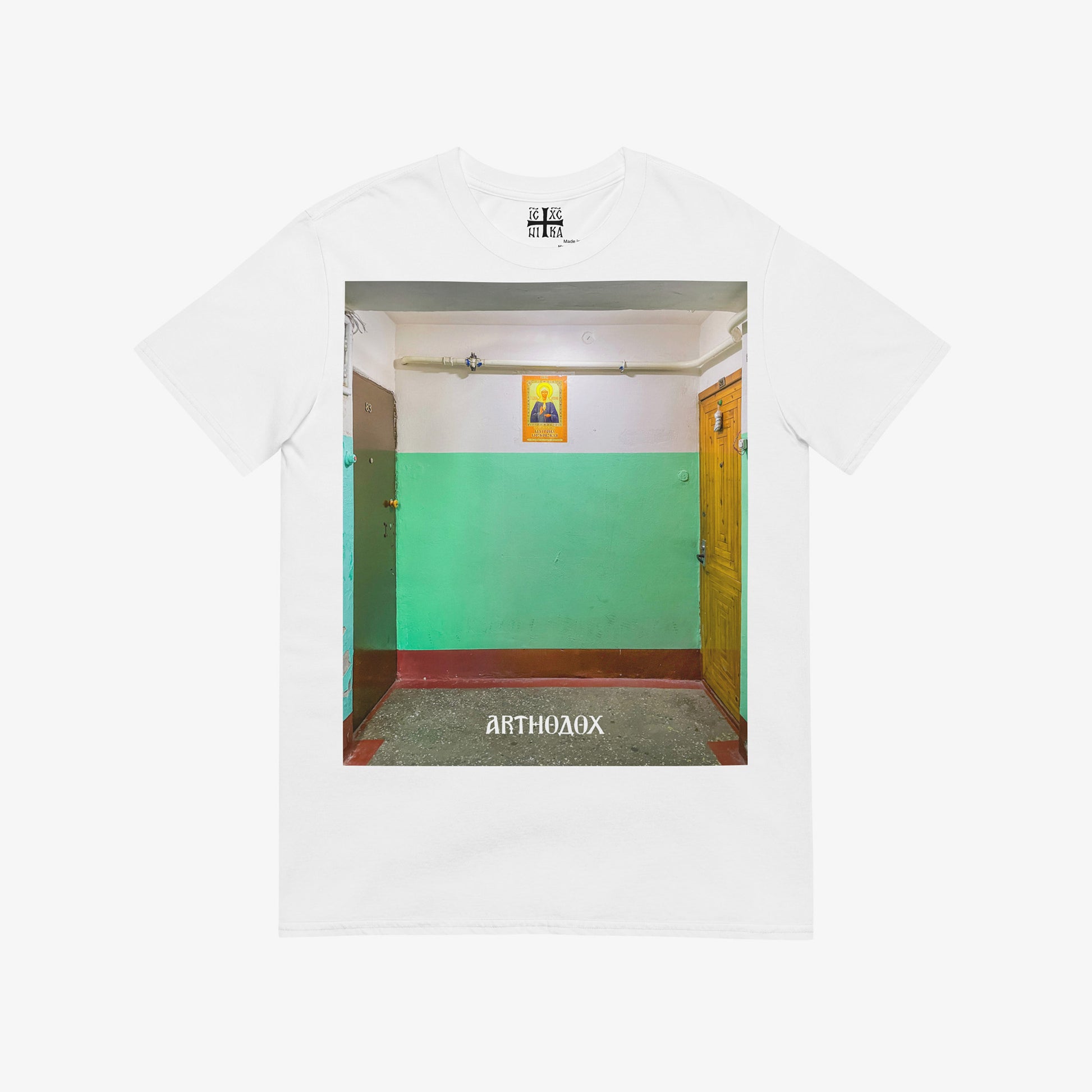 White unisex T-shirt with a large print depicting a typical Russian apartment stairwell featuring an icon of Holy Blessed Matrona of Moscow on the wall. From arthodox.com